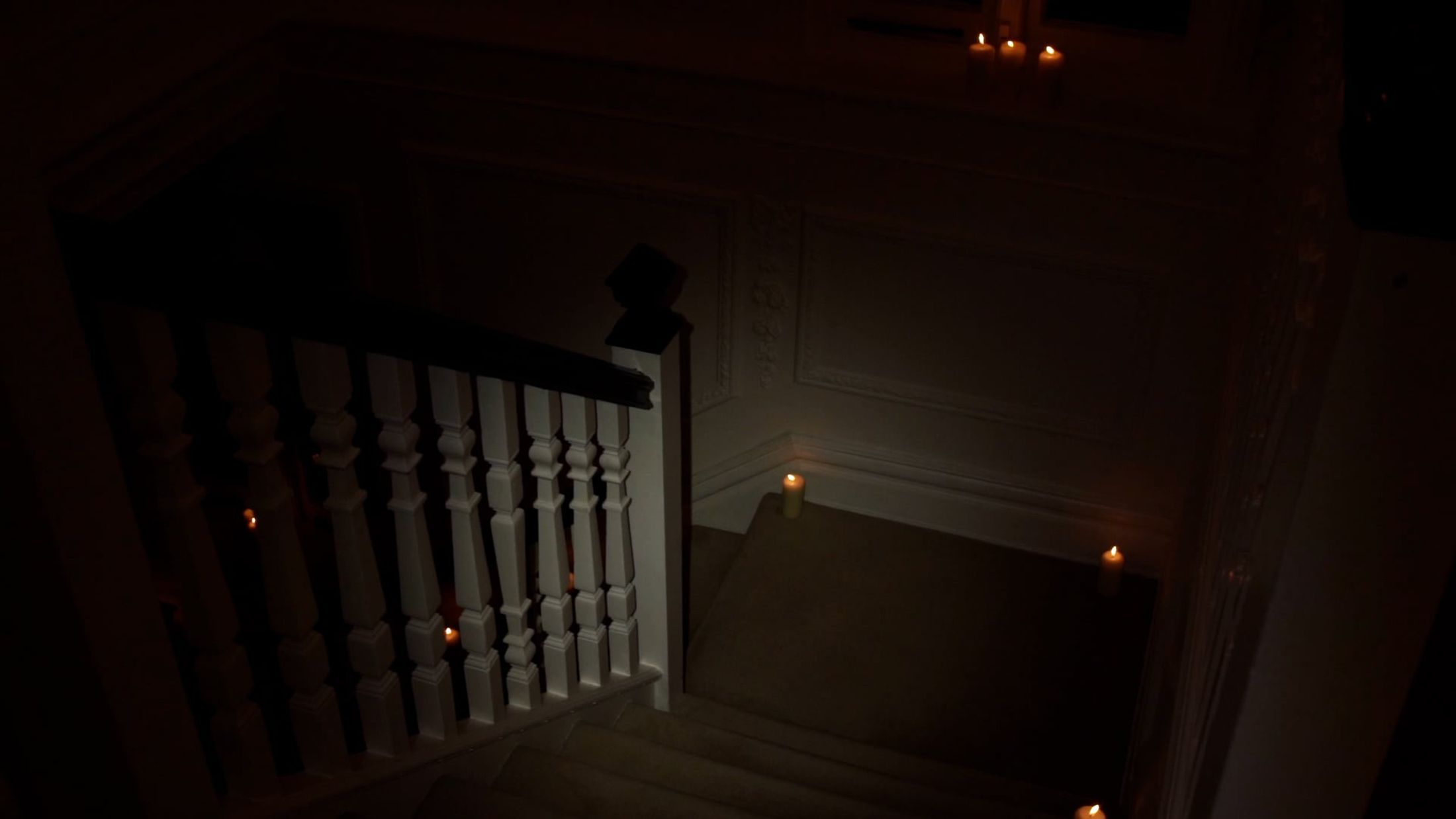 Still from Alison (2021) by Melle Nieling, descending a dark staircase