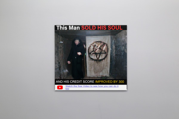print hanging on lightgrey wall, print resembles an online clickbait advert with a trick for improving your credit score by selling your soul