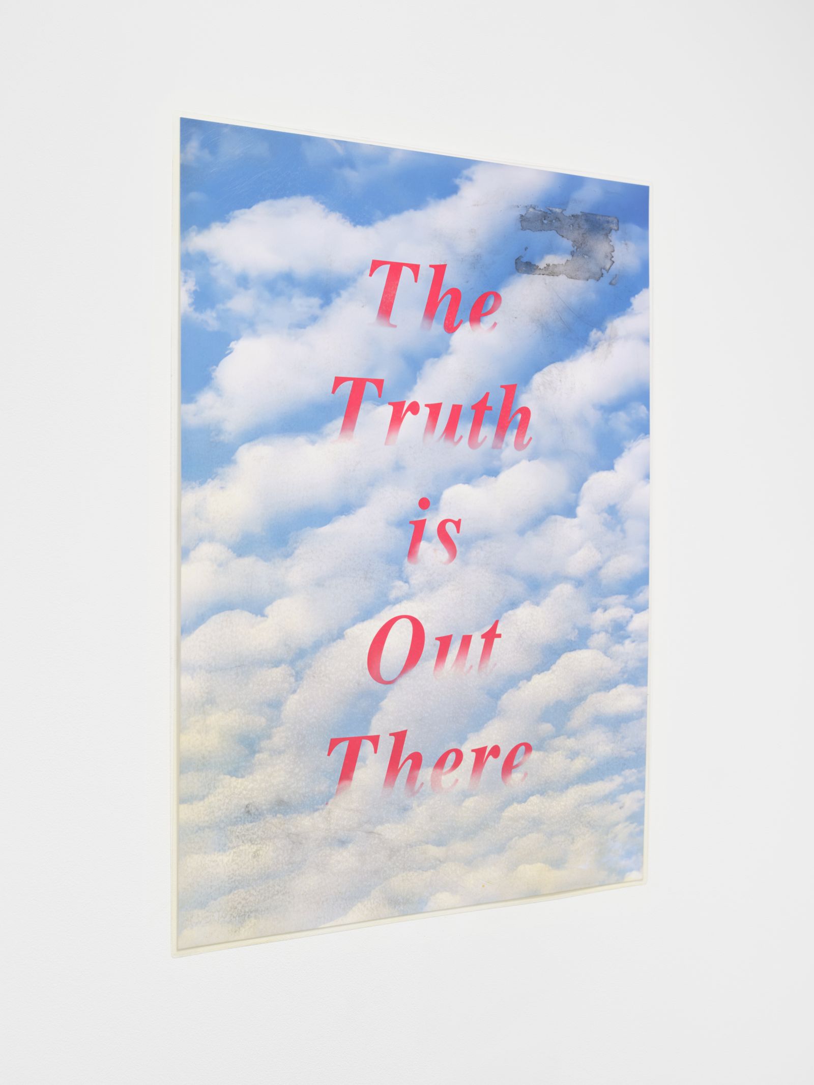 Angled close-up of the poster showing a cloudy sky and the text 