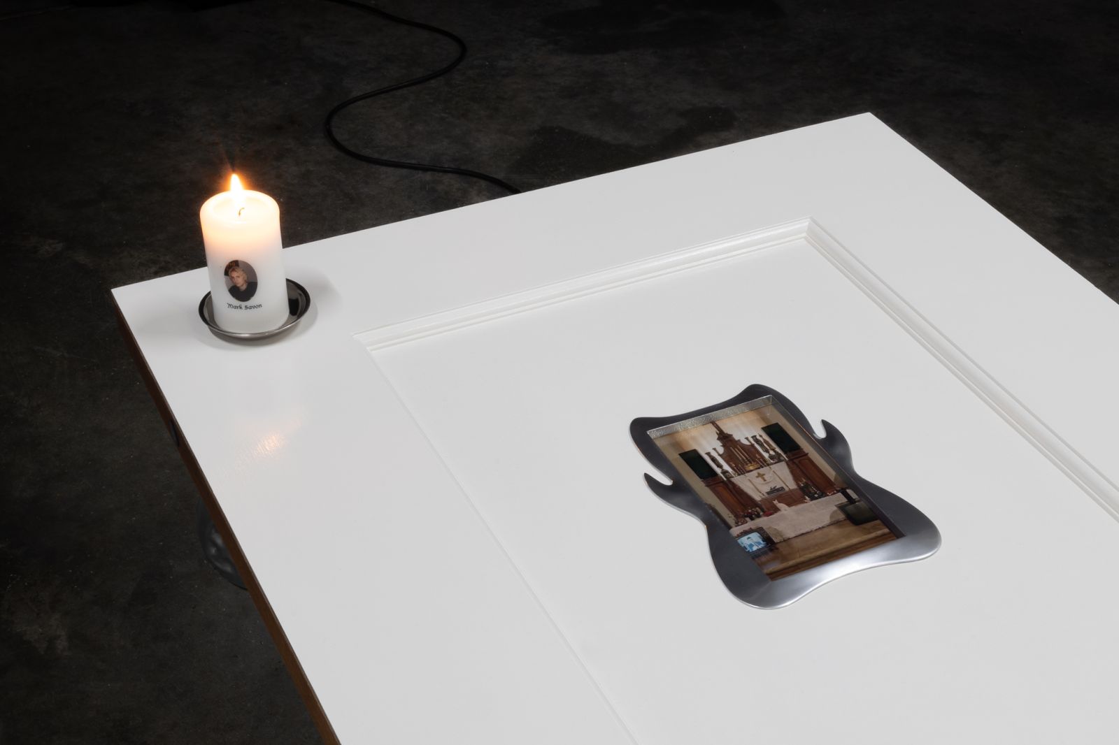 A detail of the top half of the door, showing the candle and screen