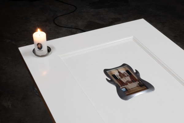 A detail of the top half of the door, showing the candle and screen