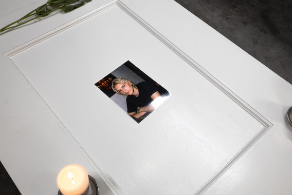 A detail of the door's bottom half, on the door lies a photograph of Mark Savon