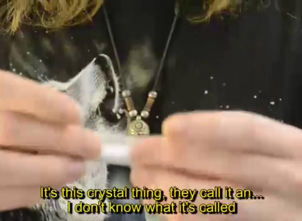 man rolling cigarette, subtitles: It's this crystal thing, they call it an... I don't know what it's called
